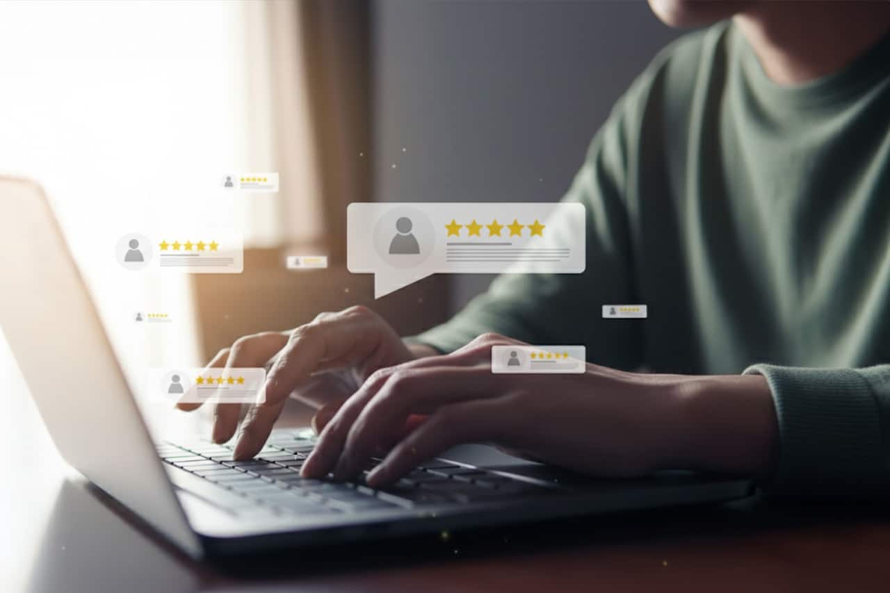 A person is typing on their laptop. Pop-ups are floating on the screen, displaying 5-star reviews of lawn and landscaping companies.