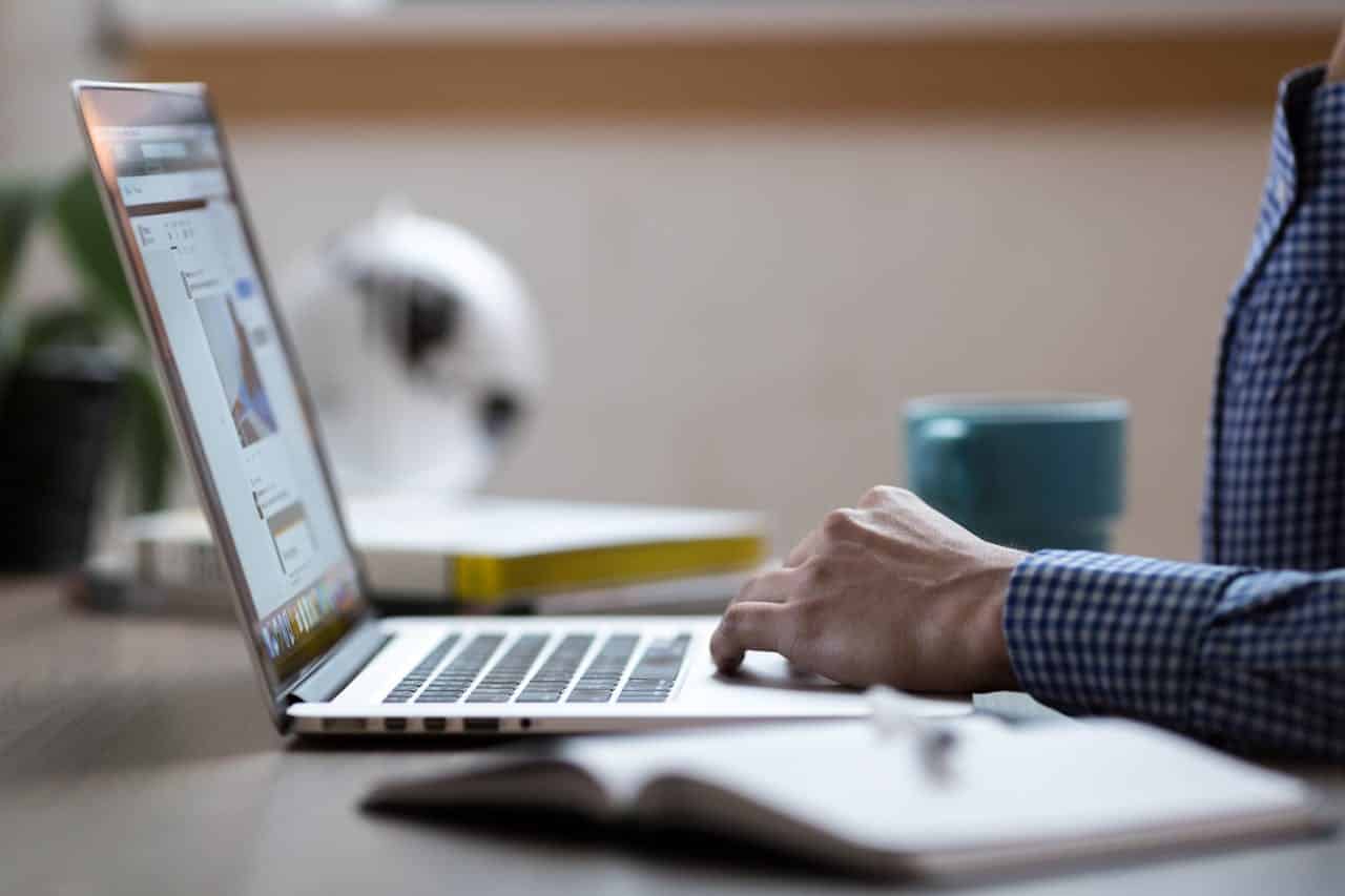A landscaping designer is planning a project for a client's yard on their laptop.